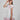 Girl in floral and flamingo print dress with scalloped cape and gathered skirt.