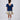 Girl in navy velvet and floral brocade dress with puff sleeves and scalloped detail.