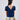 Girl in navy velvet and floral brocade dress with puff sleeves and scalloped detail.