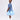 Girl wearing soft blue embroidered lace dress with puff sleeves and tulle hem.