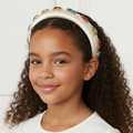 Young girl wearing a decorative headband with a white background