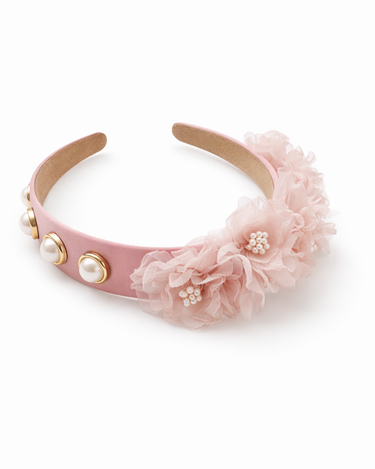 Pink headband with floral decorations and pearl embellishments on a white background