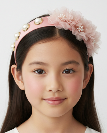 Young girl wearing a decorative headband with flowers and pearls on a white background