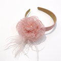 Pink headband with a flower and feathers on a white background