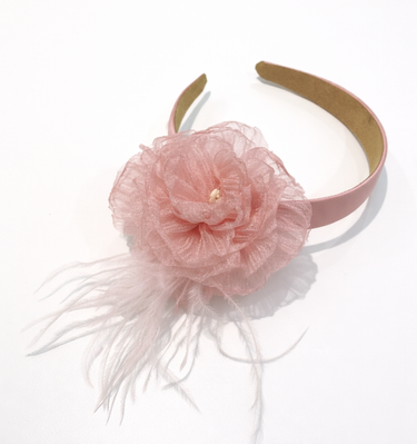 Pink headband with a flower and feathers on a white background