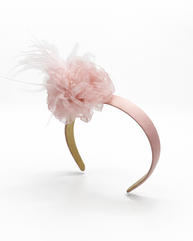 Pink headband with a fluffy pink flower on a white background