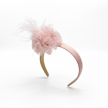 Pink headband with a fluffy pink flower on a white background