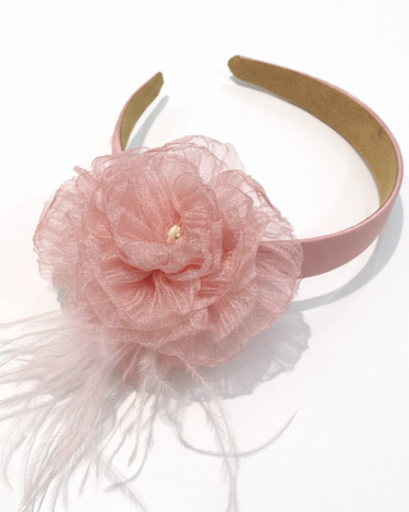 Pink headband with a large flower and feathers on a white background