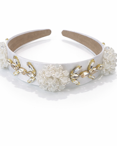 White headband with gold accents and floral decorations on a white background