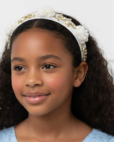 Young girl wearing a decorative headband against a white background