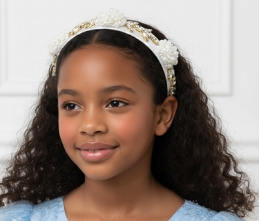 Young girl wearing a decorative headband against a white background