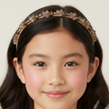 Young girl wearing a decorative headband with a plain background