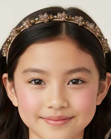 Young girl wearing a decorative headband with a plain background