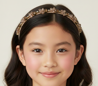 Young girl wearing a decorative headband with a plain background