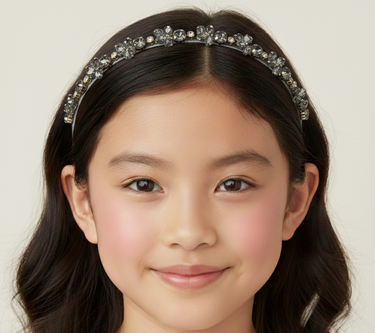 Young girl wearing a decorative headband with a plain background