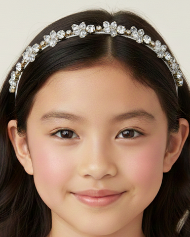 Young girl wearing a decorative headband with a plain background