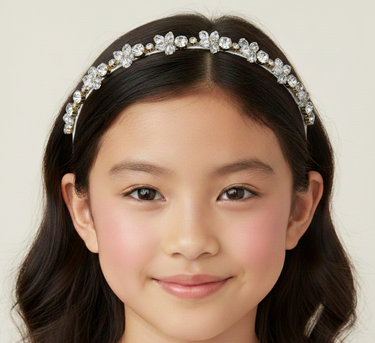 Young girl wearing a decorative headband with a plain background