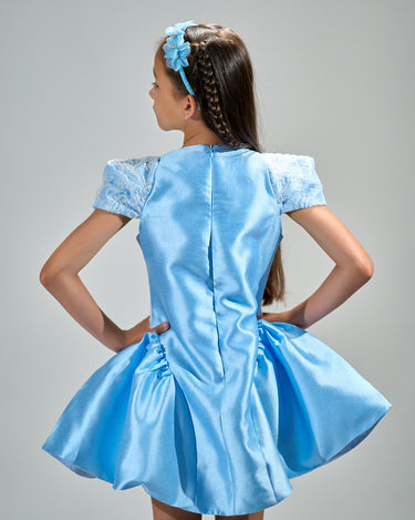 Girl in royal blue taffeta dress with sequin lace front and velvet bow accents.