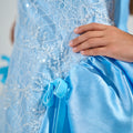 Girl in royal blue taffeta dress with sequin lace front and velvet bow accents.
