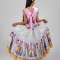 Girl in tiered Dubai-print maxi dress with lace panels and open-back tie.