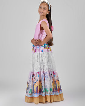 Girl in tiered Dubai-print maxi dress with lace panels and open-back tie.