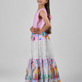 Girl in tiered Dubai-print maxi dress with lace panels and open-back tie.