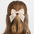 Long brown hair with a large pink bow on a white background