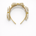 Gold headband with floral designs on a white background
