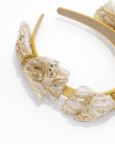 Gold and white decorative headband on a white background