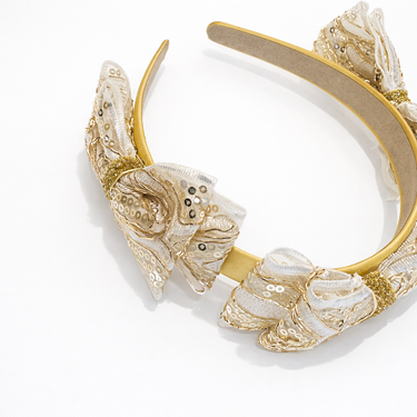 Gold and white decorative headband on a white background