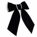 Black bow with pearl accents on a white background