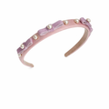 Pink headband with bows and pearls on a white background