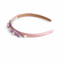 Pink headband with purple bow and pearls on a white background