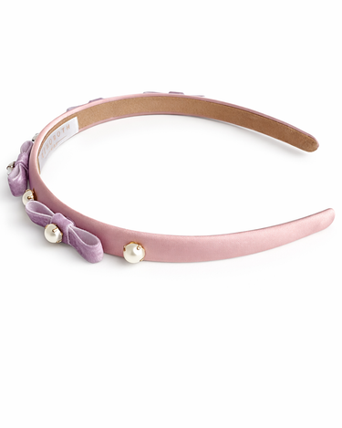 Pink headband with purple bow and pearls on a white background