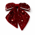 Red velvet bow with pearl embellishments on a white background