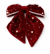 Red velvet bow with pearl embellishments on a white background