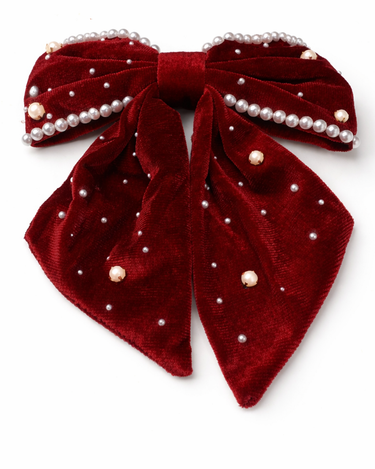 Red velvet bow with pearl embellishments on a white background