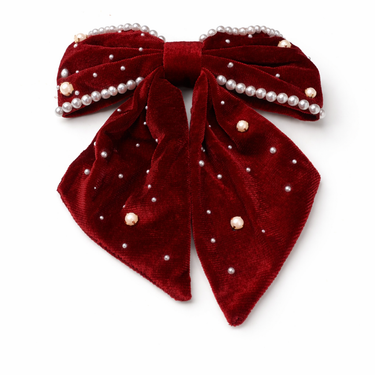 Red velvet bow with pearl embellishments on a white background