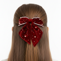 Red velvet hair bow with pearls on a white background
