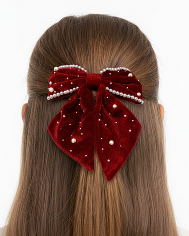Red velvet hair bow with pearls on a white background