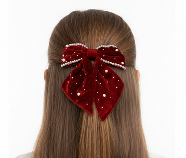 Red velvet hair bow with pearls on a white background