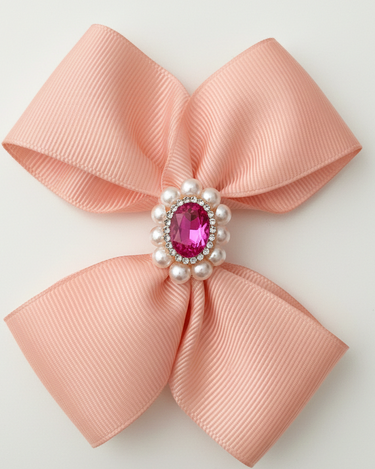 Pink bow with a central gemstone and pearls on a light gray background
