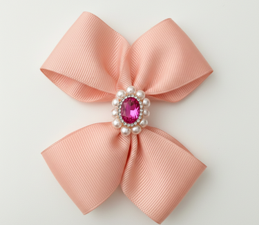 Pink bow with a central gemstone and pearls on a light gray background