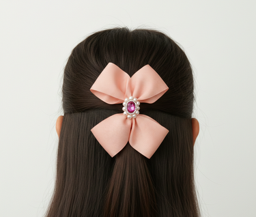 Pink hair bow with a decorative center on a mannequin head against a white background
