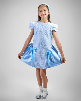 Girl in royal blue taffeta dress with sequin lace front and velvet bow accents.