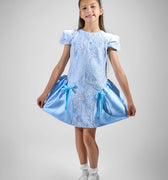 Girl in royal blue taffeta dress with sequin lace front and velvet bow accents.