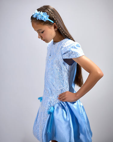 Girl in royal blue taffeta dress with sequin lace front and velvet bow accents.