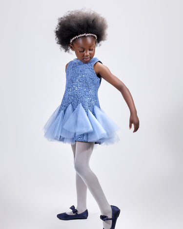 Girl in azure sequin lace dress with dramatic flared tulle hem.