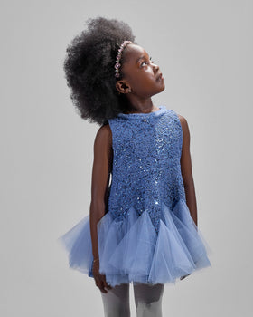 Girl in azure sequin lace dress with dramatic flared tulle hem.