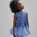 Girl in azure sequin lace dress with dramatic flared tulle hem.
